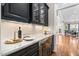 Wet bar with dark cabinets, marble countertop and wine cooler at 804 Cambridge Hall Loop, Apex, NC 27539