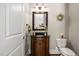 Charming powder room with wooden vanity, granite countertop, and decorative mirror at 804 Cambridge Hall Loop, Apex, NC 27539
