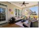 Cozy screened porch with a comfortable sectional, overhead fan, and a view of the home's exterior at 804 Cambridge Hall Loop, Apex, NC 27539