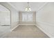 Cozy dining room with soft neutral walls, plush gray carpet, bright window, and classic chandelier at 818 Eastern Ave, Rocky Mount, NC 27801
