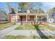 Charming red brick home featuring a covered front porch,dormers, and a well-maintained front yard at 818 Eastern Ave, Rocky Mount, NC 27801