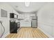 Modern kitchen features stainless steel appliances, white cabinetry, and wood grain flooring at 818 Eastern Ave, Rocky Mount, NC 27801