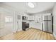 Bright kitchen with stainless steel appliances, white cabinets, and wood-look flooring at 818 Eastern Ave, Rocky Mount, NC 27801