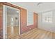 Sunroom features brick accent wall, wood floors, white trim, built-in shelving and natural light at 818 Eastern Ave, Rocky Mount, NC 27801
