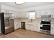 Bright kitchen features stainless steel appliances, white cabinets, and light wood-look flooring at 107 Ware Ct, Garner, NC 27529
