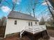 Exterior back view with a deck and backyard surrounded by tall trees at 1100 Walter Clark Dr, Hillsborough, NC 27278