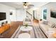 Bright, staged living room featuring modern furniture, hardwood floors, and ample natural light at 1100 Walter Clark Dr, Hillsborough, NC 27278
