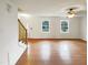Open living area with hardwood floors, staircase, and large windows providing ample natural light at 1100 Walter Clark Dr, Hillsborough, NC 27278