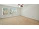 Bright bedroom featuring carpet, a ceiling fan, and multiple windows bringing in natural light at 116 Polaris Ave, Garner, NC 27529