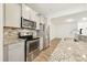 Modern kitchen featuring stainless steel appliances, granite countertops, and seamless access to the living space at 116 Polaris Ave, Garner, NC 27529