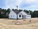 Side view of a well-maintained white house with green trees in the background at 136 Tee Time Ter, Benson, NC 27504