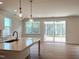 Open kitchen with large island, sink, and sliding doors leading to back patio at 136 Tee Time Ter, Benson, NC 27504