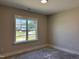 Sunlit bedroom with a view of the neighborhood through a large window at 141 Noramac Ct, Selma, NC 27576