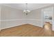 Formal dining room showcasing chair rail, hardwood floors, and modern lighting, adjacent to the kitchen at 154 Ashton Ln, Angier, NC 27501