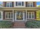 Home's inviting front porch features classic columns, large windows, and brick accents at 154 Ashton Ln, Angier, NC 27501