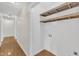 Well-lit hallway featuring wooden floors and an unfinished storage area with shelving at 154 Ashton Ln, Angier, NC 27501