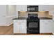 Kitchen showcases white cabinets, tile backsplash and black appliances at 154 Ashton Ln, Angier, NC 27501
