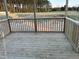 View of a wooden back porch featuring wooden railings and posts overlooking the backyard at 163 Noramac Ct, Selma, NC 27576