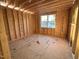 Unfinished bedroom featuring stud walls, a window providing natural light, and subflooring at 163 Noramac Ct, Selma, NC 27576