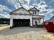 New construction home featuring a two-car garage and brick-accented entry, under construction, with a blue sky backdrop at 163 Noramac Ct, Selma, NC 27576