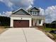 Two-story home featuring a stained garage door, light siding, and craftsman columns at 163 Noramac Ct, Selma, NC 27576