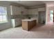 Bright kitchen featuring white cabinetry, center island, and abundant natural light at 163 Noramac Ct, Selma, NC 27576