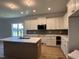 Modern white kitchen with stainless steel appliances, an island, and a stylish brick backsplash at 163 Noramac Ct, Selma, NC 27576