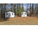 Two sheds in the backyard are surrounded by mature trees, offering ample storage space on the property at 170 Buckaroo Dr, Louisburg, NC 27549