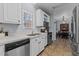 Bright kitchen features white cabinets, stainless steel appliances, and a double sink with a view of the backyard at 170 Buckaroo Dr, Louisburg, NC 27549