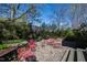 Private backyard retreat with stone patio and red outdoor seating, surrounded by lush greenery, offers a serene escape at 1714 Park Dr, Raleigh, NC 27605