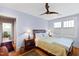 Comfortable bedroom with light blue walls, hardwood floors, ceiling fan, and bright natural light at 1714 Park Dr, Raleigh, NC 27605
