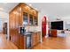 Wet bar featuring wood cabinets, sink, wine refrigerator, and glass display shelves at 1714 Park Dr, Raleigh, NC 27605