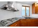 Modern kitchen with stainless steel range hood, backsplash, and window over sink at 1714 Park Dr, Raleigh, NC 27605