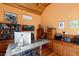 Home office with wood floors, orange walls, vaulted ceiling, large desk, and abundant storage creates a productive workspace at 1714 Park Dr, Raleigh, NC 27605