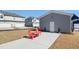 Backyard with red chairs and table set on a concrete patio, backing up to a detached garage at 236 Annabelle Blue Dr, Wake Forest, NC 27587