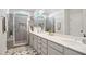 A clean bathroom with dual sinks and large shower featuring gray tile and glass doors at 236 Annabelle Blue Dr, Wake Forest, NC 27587