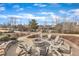 Community fire pit with Adirondack chairs, wooden railing, and pond view on a partly cloudy day at 236 Annabelle Blue Dr, Wake Forest, NC 27587