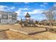 Community playground with mulch, slides, and a play structure surrounded by grassy areas and townhomes at 236 Annabelle Blue Dr, Wake Forest, NC 27587