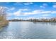 Community pond surrounded by trees, bushes, and neighborhood houses under a bright blue sky with wispy clouds at 236 Annabelle Blue Dr, Wake Forest, NC 27587