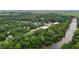 A lush, green aerial view showcasing a small town nestled along a river with trees, houses, and businesses at 2409 Hodges Rd, Burlington, NC 27217