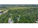 Aerial view of a densely wooded neighborhood featuring a mix of homes and local businesses by a river at 2409 Hodges Rd, Burlington, NC 27217