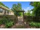 Picturesque backyard with an arbor leading to a fire pit and seating area at 2409 Hodges Rd, Burlington, NC 27217