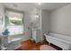 Farmhouse-style bathroom features a clawfoot tub, window, and hardwood floors at 2409 Hodges Rd, Burlington, NC 27217