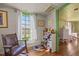Sunlit bedroom with wood floors, features a large window and cozy seating area for relaxation at 2409 Hodges Rd, Burlington, NC 27217