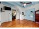 Bedroom featuring hardwood floors, a ceiling fan, blue ceiling and a connecting door to another room at 2409 Hodges Rd, Burlington, NC 27217