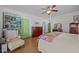 Bright bedroom features a patterned quilt, hardwood floors, and colorful bookshelf with natural light at 2409 Hodges Rd, Burlington, NC 27217