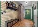 Inviting entryway with brick accent wall, wooden bench, and storage baskets at 2409 Hodges Rd, Burlington, NC 27217