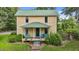 Charming yellow home featuring a covered front porch with steps and inviting blue chairs for relaxing at 2409 Hodges Rd, Burlington, NC 27217