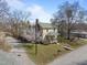 Two-story home featuring green roof, inviting porch, and blossoming tree at 2409 Hodges Rd, Burlington, NC 27217