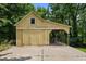 A yellow garage with a concrete foundation sits beneath the shade of mature trees at 2409 Hodges Rd, Burlington, NC 27217